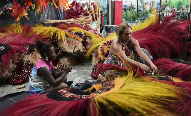 Transgender women Negriny Venture, left, and Leticia Mamede prepare Carnival costumes for the Paraiso de Tuiuti samba school in Rio de Janeiro, Wednesday, Feb. 12, 2025. (AP Photo/Silvia Izquierdo)