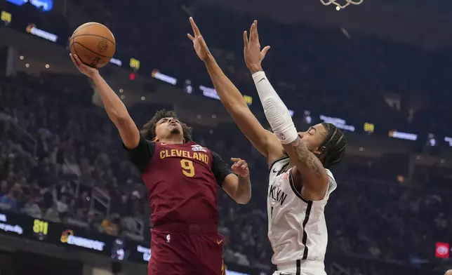Cleveland Cavaliers guard Craig Porter Jr. (9) shoots as Brooklyn Nets' Trenton Watgford, right, defends in the first half of an NBA basketball game Tuesday, March 11, 2025, in Cleveland. (AP Photo/Sue Ogrocki)