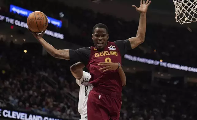 Cleveland Cavaliers guard Javonte Green (8) is fouled from behind by Brooklyn Nets forward Ziaire Williams, rear, in the first half of an NBA basketball game Tuesday, March 11, 2025, in Cleveland. (AP Photo/Sue Ogrocki)