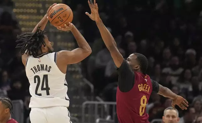Brooklyn Nets guard Cam Thomas shoots as Cleveland Cavaliers guard Javonte Green (8) defends in the first half of an NBA basketball game Tuesday, March 11, 2025, in Cleveland. (AP Photo/Sue Ogrocki)
