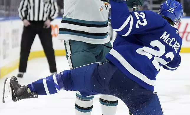 San Jose Sharks forward Tyler Toffoli, front left, checks Toronto Maple Leafs defenseman Jake McCabe (22) during third-period NHL hockey game action in Toronto, Monday, March 3, 2025. (Nathan Denette/The Canadian Press via AP