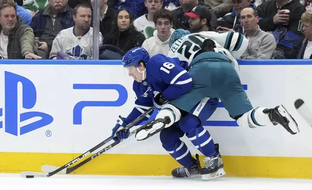 San Jose Sharks forward Fabian Zetterlund (20) checks Toronto Maple Leafs forward Mitch Marner (16) who carries the puck during third-period NHL hockey game action in Toronto, Monday, March 3, 2025. (Nathan Denette/The Canadian Press via AP
