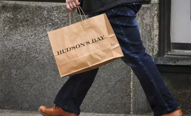 A shopper leaves the Hudson's Bay store in downtown Calgary, Alberta, Thursday, March 20, 2025. (Jeff McIntosh/The Canadian Press via AP)