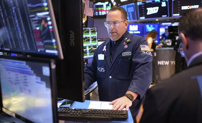 People work on the floor at the New York Stock Exchange in New York, Wednesday, March 19, 2025. (AP Photo/Seth Wenig)