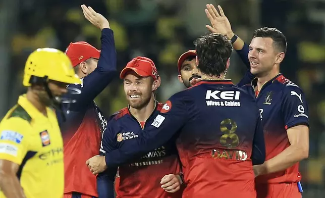 Royal Challengers Bengaluru's Josh Hazlewood, right, celebrates with teammates after the dismissal of Chennai Super Kings' Rahul Tripathi, left, during the Indian Premier League cricket match between Chennai Super Kings and Royal Challengers Bengaluru at M. A. Chidambaram Stadium in Chennai, India, Friday, March 28, 2025. (AP Photo/R. Parthibhan)