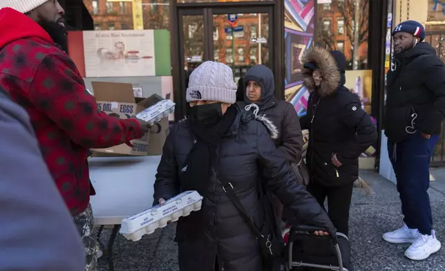 Abou Sow hands out cartons of eggs to people waiting in line to receive free eggs from FarmerJawn Agriculture, Friday, March 21, 2025, in the Harlem neighborhood of New York. (AP Photo/Julia Demaree Nikhinson)