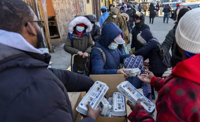 Abou Sow hands out cartons of eggs to people waiting in line to receive free eggs from FarmerJawn Agriculture, Friday, March 21, 2025, in the Harlem neighborhood of New York. (AP Photo/Julia Demaree Nikhinson)