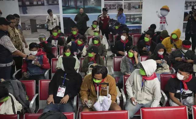 Indonesia nationals who had worked at scam centers in eastern Myanmar sit in a waiting room upon arrival from Thailand, at Soekarno-Hatta International Airport in Tangerang, Indonesia, Friday, Feb. 28, 2025.(AP Photo/Tatan Syuflana)