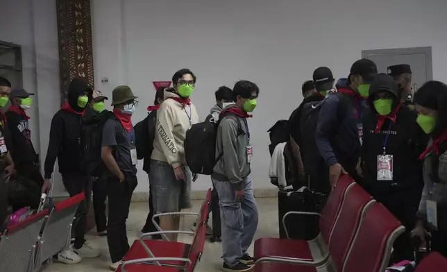Indonesia nationals who had worked at scam centers in eastern Myanmar walk into a waiting room upon arrival from Thailand, at Soekarno-Hatta International Airport in Tangerang, Indonesia, Friday, Feb. 28, 2025.(AP Photo/Tatan Syuflana)