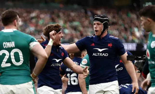France's Oscar Jegou, centre, celebrates with his teammate Thibaud Flament, after scoring a try during the Six Nations rugby union match between Ireland and France, at Aviva Stadium, Dublin, Ireland, Saturday, March 8, 2025. (AP Photo/Peter Morrison)