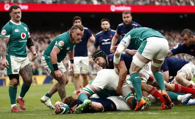 France's Oscar Jegou, bottom, scores a try during the Six Nations rugby union match between Ireland and France, at Aviva Stadium, Dublin, Ireland, Saturday, March 8, 2025. (AP Photo/Peter Morrison)