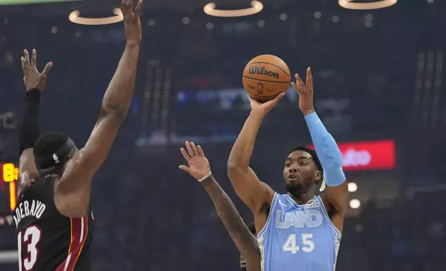 Cleveland Cavaliers guard Donovan Mitchell (45) shoots in front of Miami Heat center Bam Adebayo (13 in the first half of an NBA basketball game Wednesday, March 5, 2025, in Cleveland. (AP Photo/Sue Ogrocki)