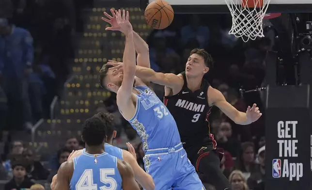 Miami Heat guard Pelle Larsson (9) fouls Cleveland Cavaliers forward Dean Wade (32) in the first half of an NBA basketball game Wednesday, March 5, 2025, in Cleveland. (AP Photo/Sue Ogrocki)