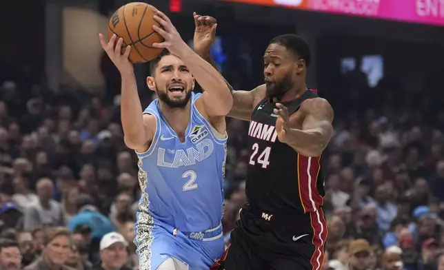 Cleveland Cavaliers guard Ty Jerome (2) drives past Miami Heat forward Haywood Highsmith (24) in the first half of an NBA basketball game Wednesday, March 5, 2025, in Cleveland. (AP Photo/Sue Ogrocki)