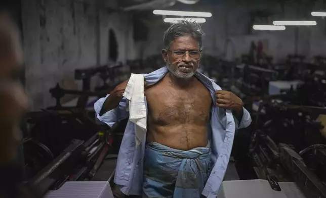 Islam-ud-din Ansari, 62, smokes a beedi, a thin leaf-wrapped cigarette, during a break at a power loom workshop in Bhiwandi, India, Feb. 27, 2025. (AP Photo/Rafiq Maqbool)