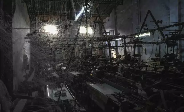 Cobwebs cover the machines at a non-operating power loom workshop in Bhiwandi, India, Feb. 27, 2025. (AP Photo/Rafiq Maqbool)