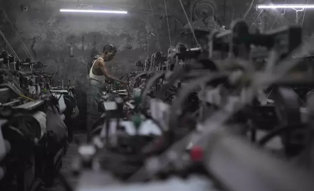 A worker operates a power loom at a workshop in Bhiwandi, India, Feb. 25, 2025. (AP Photo/Rafiq Maqbool)