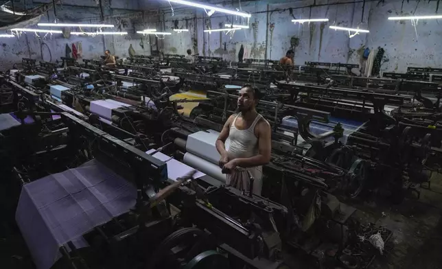 A workers operates a power loom at a workshop in Bhiwandi, India, Feb. 27, 2025. (AP Photo/Rafiq Maqbool)
