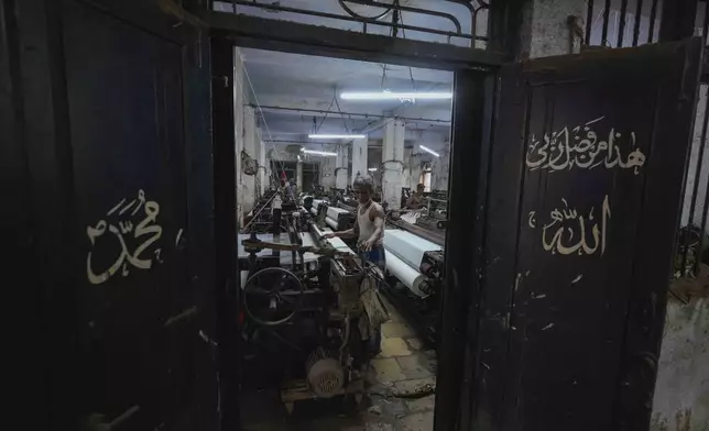Mohammed Amat, 40, operates a power loom at a workshop in Bhiwandi, India, Feb. 27, 2025. (AP Photo/Rafiq Maqbool)
