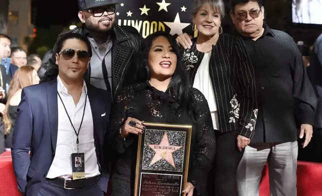 FILE - Suzette Quintanilla, center, sister of the late singer Selena Quintanilla, holds a replica of Selena's star on the Hollywood Walk of Fame as she poses with, from left, Selena's husband Chris Perez, her brother A.B. Quintanilla III, and her parents Marcella Ofelia Samora and Abraham Quintanilla Jr. during a posthumous ceremony on the Hollywood Walk of Fame in Los Angeles on Nov. 3, 2017. (Photo by Chris Pizzello/Invision/AP, File)