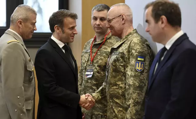 French President Emmanuel Macron, second left, , shakes hands with Colonel-General Ruslan Khomchak, First Deputy Secretary of the National Security and Defense Council of Ukraine, as French Defense Minister Sebastien Lecornu, right, and Chief of Staff of the French Armed Forces Thierry Burkhard, left, look on during a meeting on the conflict in Ukraine at the Musee de la Marine as part of the Paris Defense and Strategy Forum in Paris, Tuesday, March 11, 2025. (Sarah Meyssonnier/Pool via AP)