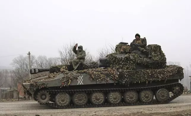 In this photo taken from video distributed by Russian Defense Ministry Press Service on Friday, March 14, 2025, Russian soldiers ride atop of self-propelled gun at an area in the Kursk region of Russia after it was taken over by Russian troops. (Russian Defense Ministry Press Service via AP)