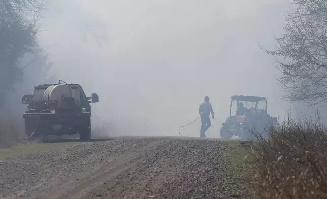 Fire crews and volunteers battle hot spots and new fires about several miles west of Stillwater, Okla., on Monday, March 17, 2025. (AP Photo/Alonzo Adams)