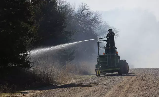 Fire crews and volunteers battle hot spots and new fires 8 miles west of Stillwater, Okla. on Monday, March 17, 2025. (AP Photo/Alonzo Adams)