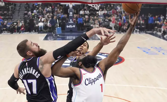 Los Angeles Clippers guard James Harden, right, shoots as Sacramento Kings center Jonas Valanciunas, left, and forward Keegan Murray defend during the first half of an NBA basketball game Sunday, March 9, 2025, in Inglewood, Calif. (AP Photo/Mark J. Terrill)