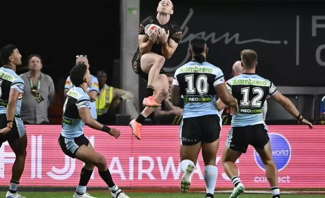 Penrith Panthers Dylan Edwards leaps to catch the ball during Australia's National Rugby League game between the Penrith Panthers and Cronulla Sutherland-Sharks at Allegiant Stadium in Las Vegas, Saturday, March 1, 2025. (AP Photo/David Becker)