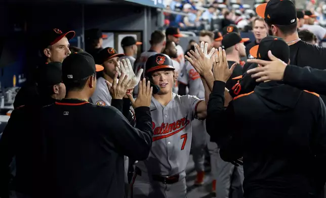 Baltimore Orioles' Jackson Holliday (7) celebrates with teammates after hitting a solo home run against the Toronto Blue Jays during third-inning baseball game action in Toronto, Friday, March 28, 2025. (Christopher Katsarov/The Canadian Press via AP)