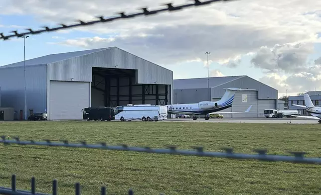 A plane believed to be carrying former Philippine President Rodrigo Duterte is parked next to a bus at Rotterdam The Hague Airport in the Netherlands, Wednesday, March 12, 2025. (AP Photo/Mark Carlson)