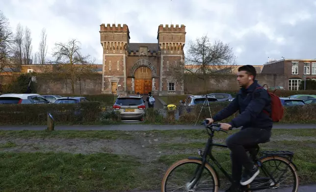 A cyclist drives past one of the entrances to the International Criminal Court detention center near The Hague in Scheveningen, Netherlands, Wednesday, March 12, 2025. (AP Photo/Omar Havana)