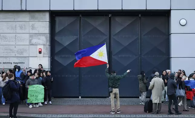 A supporter of former Philippine President Rodrigo Duterte waves a flag during a demonstration outside the International Criminal Court detention center near The Hague in Scheveningen, Netherlands, Wednesday, March 12, 2025. (AP Photo/Omar Havana)