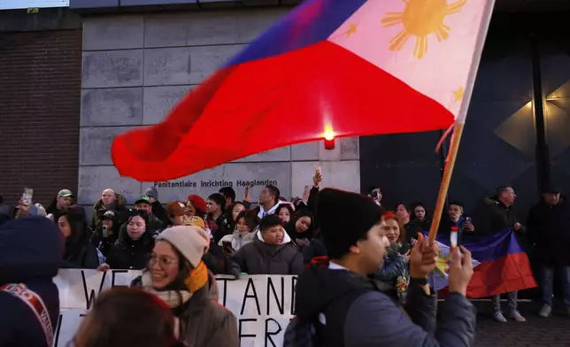 Supporters of former Philippine President Rodrigo Duterte hold flags and banners during a demonstration outside the International Criminal Court detention center near The Hague in Scheveningen, Netherlands, Wednesday, March 12, 2025. (AP Photo/Omar Havana)