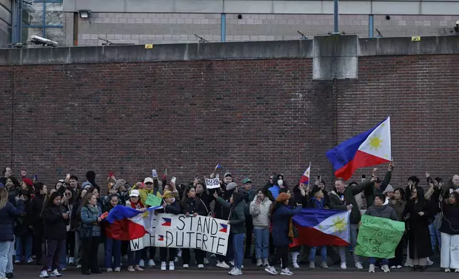 Supporters of former Philippine President Rodrigo Duterte hold flags and banners during a demonstration outside the International Criminal Court detention center near The Hague in Scheveningen, Netherlands, Wednesday, March 12, 2025. (AP Photo/Omar Havana)