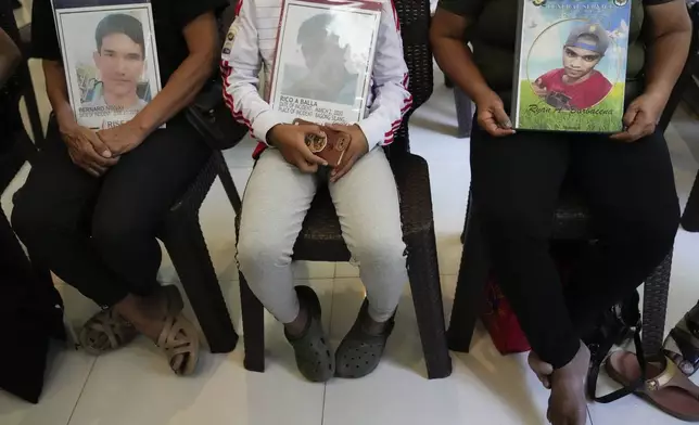 Relatives hold pictures of victims of alleged extra-judicial killings during a press conference a day after the arrest of former Philippine president Rodrigo Duterte in Quezon City, Philippines on Wednesday, March 12, 2025. (AP Photo/Aaron Favila)