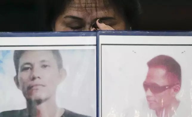 Llore Pasco wipes tears behind pictures of her sons who were victims of alleged extra-judicial killings as she attends a press conference a day after the arrest of former Philippine president Rodrigo Duterte in Quezon City, Philippines on Wednesday, March 12, 2025. (AP Photo/Aaron Favila)