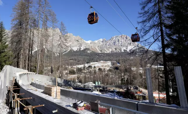 FILE - Construction work takes place at the Cortina Sliding Center, venue for the bob, luge and skeleton disciplines at the Milan Cortina 2026 Winter Olympics, in Cortina d'Ampezzo, Italy, Thursday, Jan. 16, 2025. (AP Photo/Giovanni Auletta, file)
