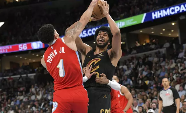 Cleveland Cavaliers center Jarrett Allen (31) shoots against Memphis Grizzlies guard Scotty Pippen Jr. (1) and is fouled from behind by Grizzlies guard Ja Morant in the first half of an NBA basketball game Friday, March 14, 2025, in Memphis, Tenn. (AP Photo/Brandon Dill)
