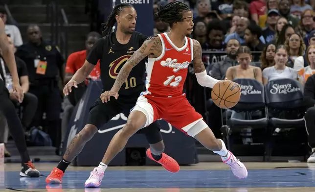 Memphis Grizzlies guard Ja Morant (12) handles the ball against Cleveland Cavaliers guard Darius Garland (10) in the first half of an NBA basketball game Friday, March 14, 2025, in Memphis, Tenn. (AP Photo/Brandon Dill)