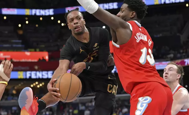 Cleveland Cavaliers guard Darius Garland (10) passes against Memphis Grizzlies forward Jaren Jackson Jr. (13) in the first half of an NBA basketball game Friday, March 14, 2025, in Memphis, Tenn. (AP Photo/Brandon Dill)