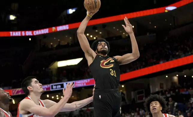 Cleveland Cavaliers center Jarrett Allen (31) shoots between Memphis Grizzlies forward Jaren Jackson Jr., from left, center Zach Edey and forward Jaylen Wells in the first half of an NBA basketball game Friday, March 14, 2025, in Memphis, Tenn. (AP Photo/Brandon Dill)