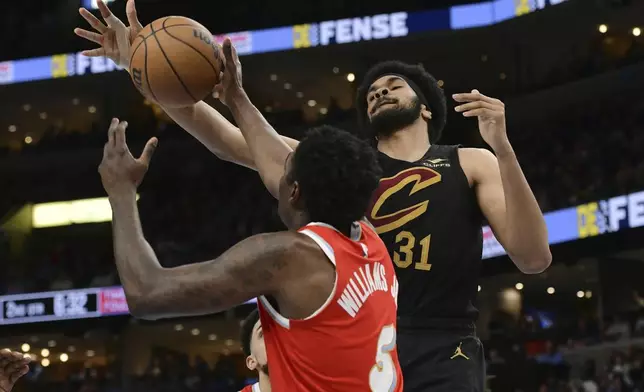 Memphis Grizzlies guard Vince Williams Jr. (5) and Cleveland Cavaliers center Jarrett Allen (31) reach for the ball in the first half of an NBA basketball game Friday, March 14, 2025, in Memphis, Tenn. (AP Photo/Brandon Dill)