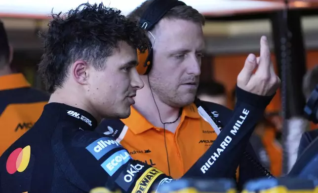 McLaren driver Lando Norris of Britain gestures as he talks with a team mechanic during the first practice session for the Australian Formula One Grand Prix at Albert Park, in Melbourne, Australia, Friday, March 14, 2025. (AP Photo/Asanka Brendon Ratnayake)