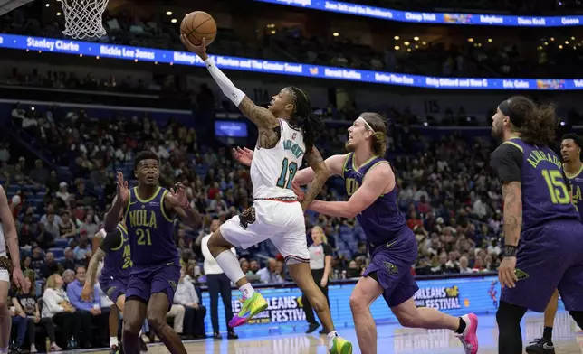 Memphis Grizzlies guard Ja Morant (12) shoots against New Orleans Pelicans forward Kelly Olynyk (13) during the first half of an NBA basketball game in New Orleans, Sunday, March 9, 2025. (AP Photo/Matthew Hinton)