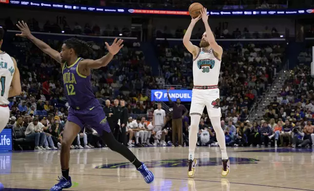 Memphis Grizzlies center Jay Huff (30) shoots a three-point basket during the first half of an NBA basketball game against the New Orleans Pelicans in New Orleans, Sunday, March 9, 2025. (AP Photo/Matthew Hinton)
