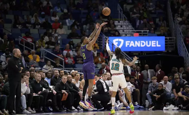 New Orleans Pelicans forward Jamal Cain (8) makes a three-point basket against Memphis Grizzlies guard Ja Morant (12) during the first half of an NBA basketball game in New Orleans, Sunday, March 9, 2025. (AP Photo/Matthew Hinton)