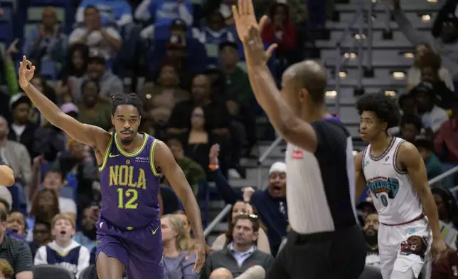 New Orleans Pelicans guard Antonio Reeves (12) celebrates a three-point basket against Memphis Grizzlies forward Jaylen Wells (0) during the first half of an NBA basketball game in New Orleans, Sunday, March 9, 2025. (AP Photo/Matthew Hinton)