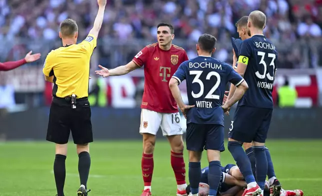 Bayern's Joao Palhinha is shown a red card by referee Christian Dingert during the German Bundesliga soccer match between Bayern Munich and VfL Bochum at the Allianz Arena in Munich, Germany, Saturday, March 8, 2025. (Sven Hoppe/dpa via AP)